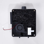 Inside view of the external carbon filter. Black electronic component with carbon pellets, fan and wires on a white background