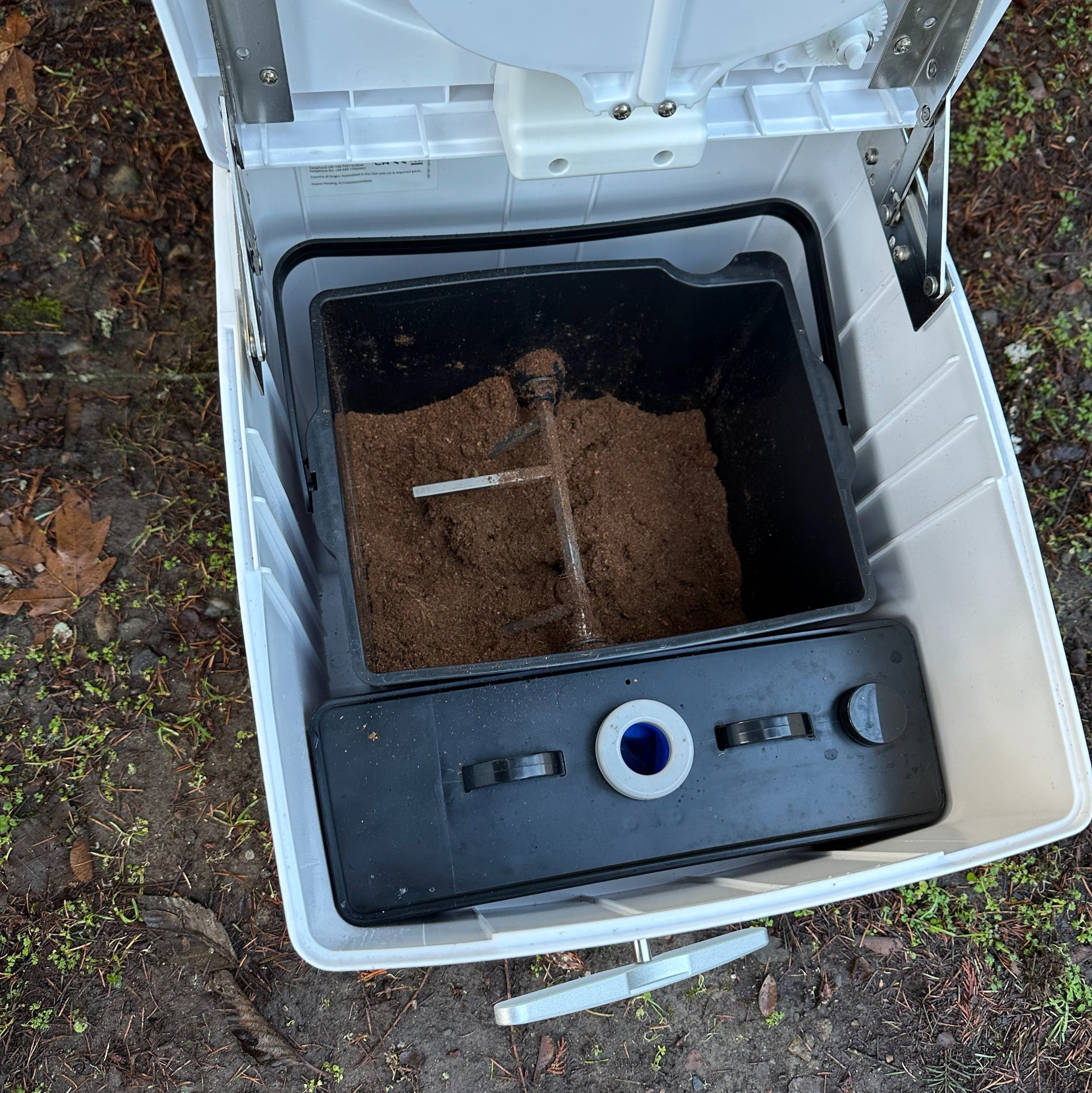 Cuddy composting toilet with the lid open to show the agitator inside